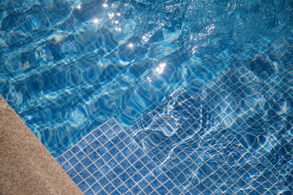 detalle de lámina armada en piscina con agua limpia y acabado tipo mosaico