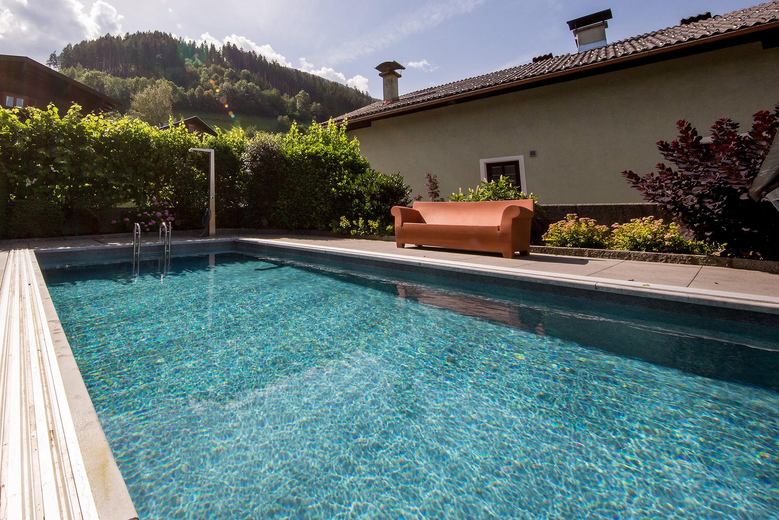 piscina integrada junto a una vivienda y jardín