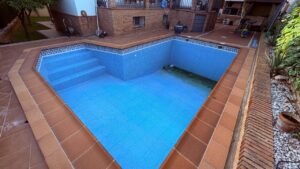 piscina antigua vacía con revestimiento deteriorado preparada para reforma integral