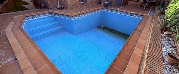 piscina antigua vacía con revestimiento deteriorado preparada para reforma integral